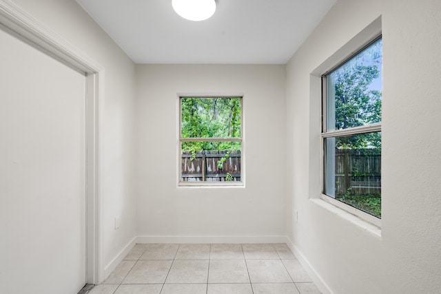 empty room with plenty of natural light and light tile patterned flooring