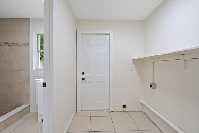 clothes washing area featuring electric dryer hookup and light tile patterned floors