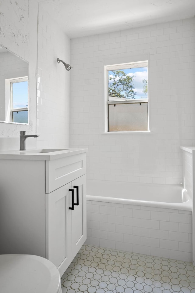 full bathroom featuring plenty of natural light, vanity, and tiled shower / bath combo