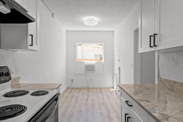 kitchen featuring light stone counters, a textured ceiling, light hardwood / wood-style flooring, white electric stove, and white cabinetry