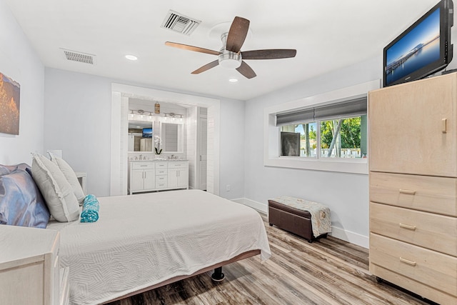 bedroom featuring hardwood / wood-style flooring, ceiling fan, and connected bathroom