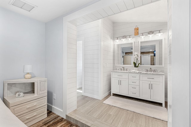 bathroom featuring dual bowl vanity, lofted ceiling, and wood-type flooring