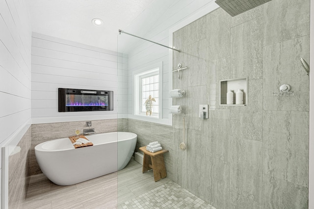 bathroom featuring tile floors, a bathing tub, and tile walls