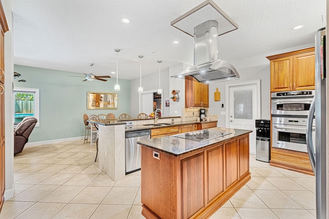 kitchen featuring a kitchen island, island range hood, stainless steel appliances, a breakfast bar area, and kitchen peninsula