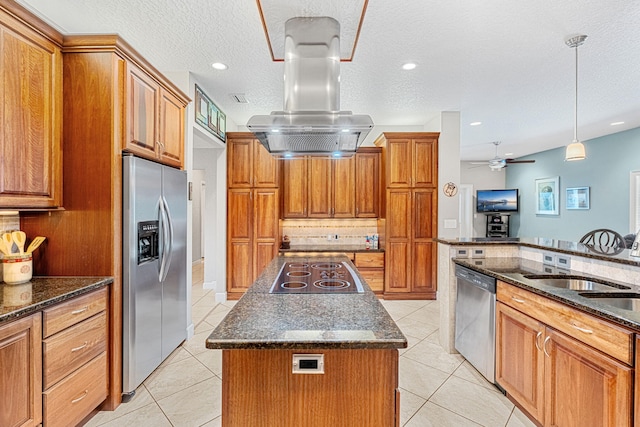 kitchen featuring dark stone counters, island range hood, ceiling fan, a center island, and appliances with stainless steel finishes