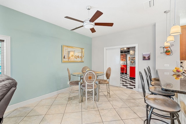 tiled dining area with ceiling fan