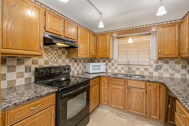 kitchen featuring sink, black electric range, dark stone counters, decorative light fixtures, and track lighting