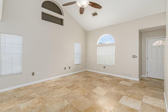 empty room with ceiling fan and high vaulted ceiling