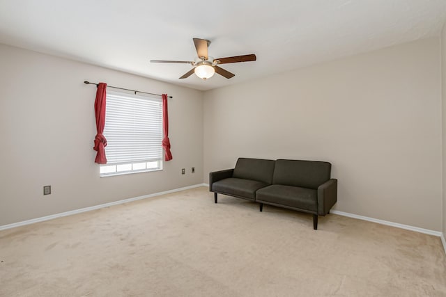 living area featuring light colored carpet and ceiling fan