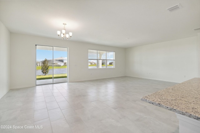 unfurnished room with light tile patterned floors and an inviting chandelier