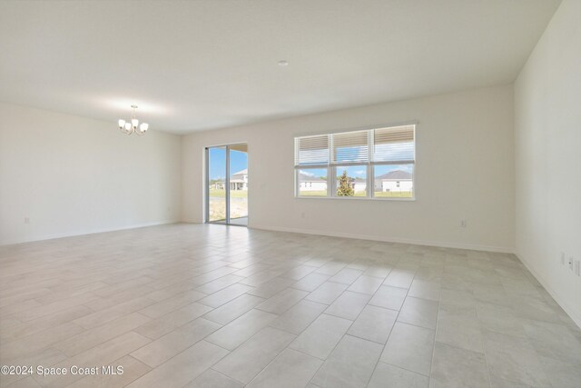 unfurnished room featuring a notable chandelier