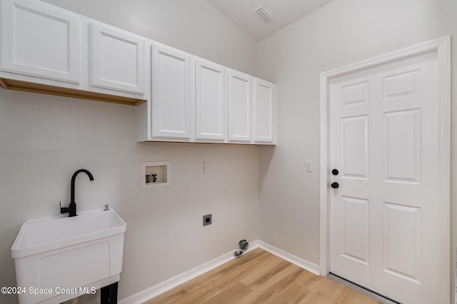 washroom featuring hookup for a washing machine, hookup for an electric dryer, light wood-type flooring, sink, and cabinets