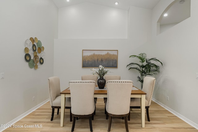 dining space featuring light hardwood / wood-style floors and vaulted ceiling