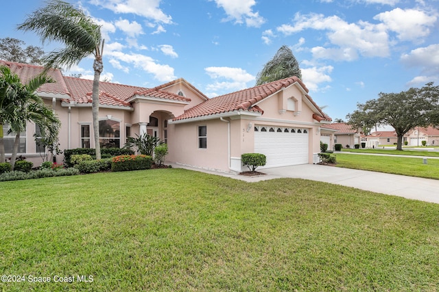 mediterranean / spanish-style home with a front yard and a garage