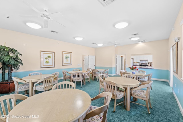 carpeted dining area with ceiling fan