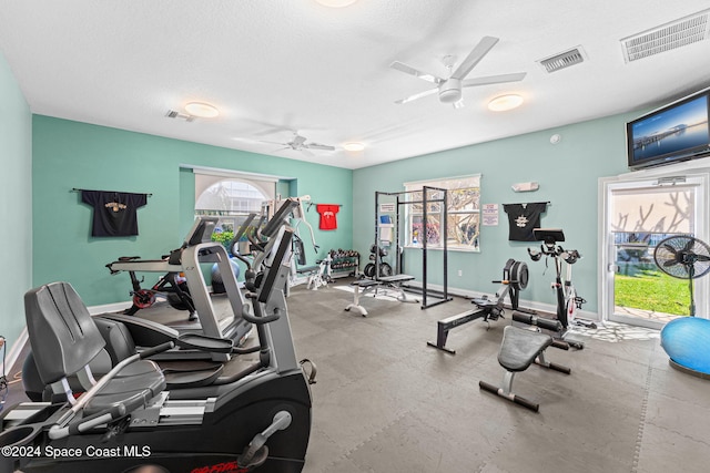 workout area featuring ceiling fan and a textured ceiling