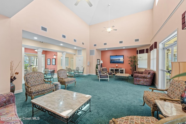 living room with carpet, a towering ceiling, decorative columns, and ceiling fan