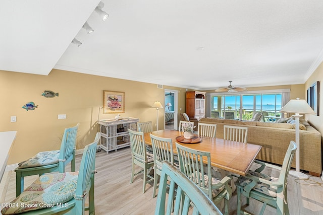 dining area with light hardwood / wood-style flooring, ornamental molding, and ceiling fan