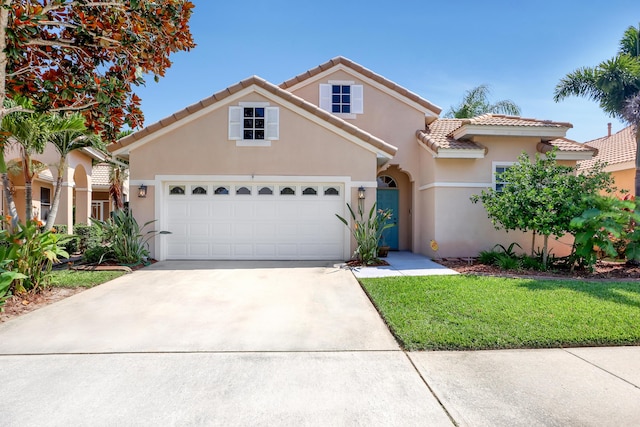 mediterranean / spanish-style home with a front lawn and a garage