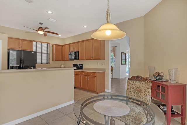 kitchen featuring black appliances, hanging light fixtures, ceiling fan, light tile patterned floors, and kitchen peninsula