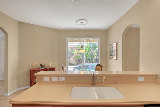 kitchen featuring decorative light fixtures, light tile patterned floors, and sink