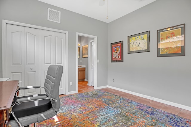 tiled home office featuring ceiling fan