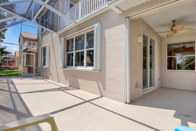 view of patio / terrace with ceiling fan and glass enclosure