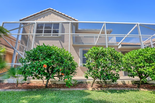 view of front of house featuring a lanai and a balcony