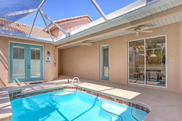 view of pool with ceiling fan, a patio area, glass enclosure, and french doors