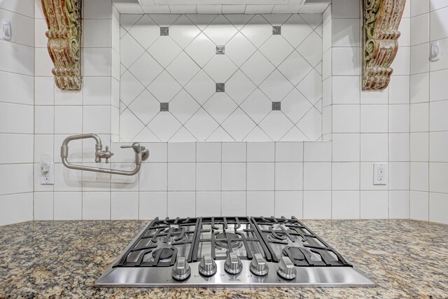 kitchen featuring stainless steel gas cooktop and dark stone countertops