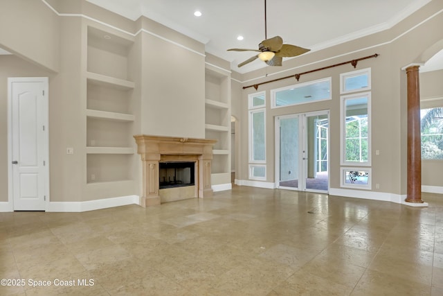 unfurnished living room with ornate columns, crown molding, built in features, and ceiling fan