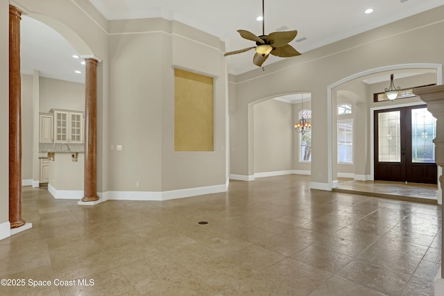 foyer entrance featuring french doors, ceiling fan, and ornate columns