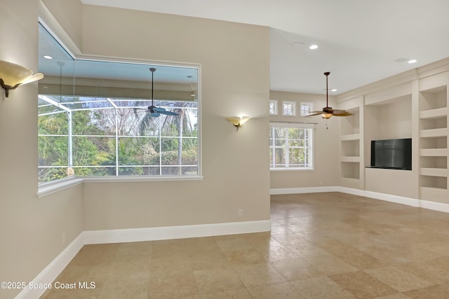 unfurnished living room with a wealth of natural light, ceiling fan, and built in shelves