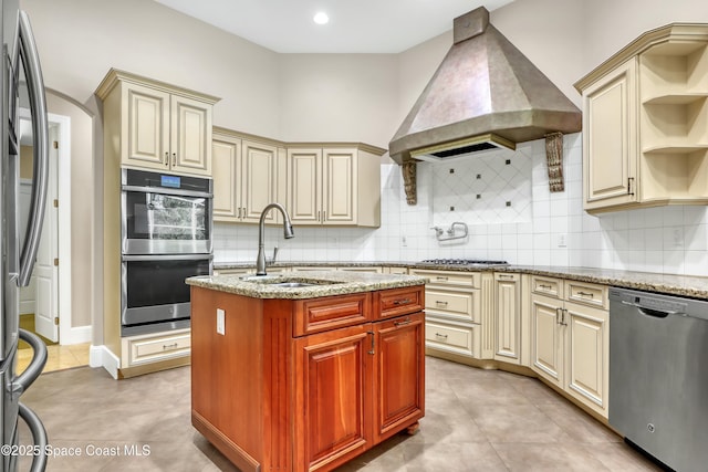 kitchen featuring sink, custom exhaust hood, light tile patterned floors, appliances with stainless steel finishes, and cream cabinetry