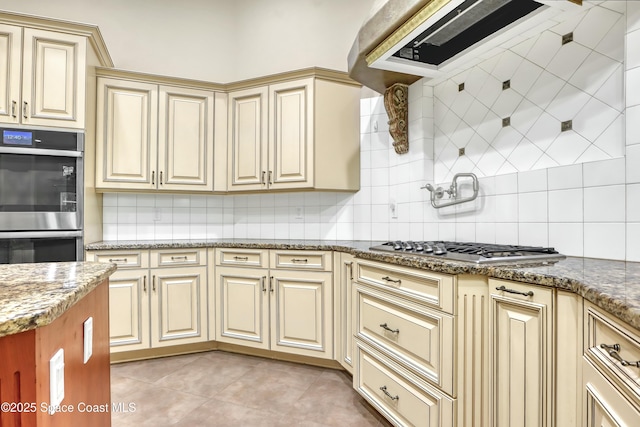 kitchen with tasteful backsplash, light tile patterned floors, stainless steel appliances, light stone countertops, and exhaust hood