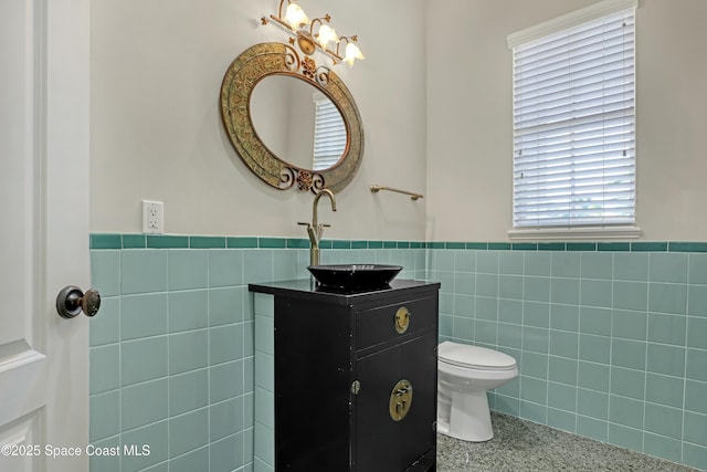 bathroom featuring tile walls, vanity, and toilet