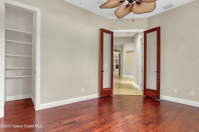 unfurnished bedroom featuring ceiling fan and dark hardwood / wood-style floors