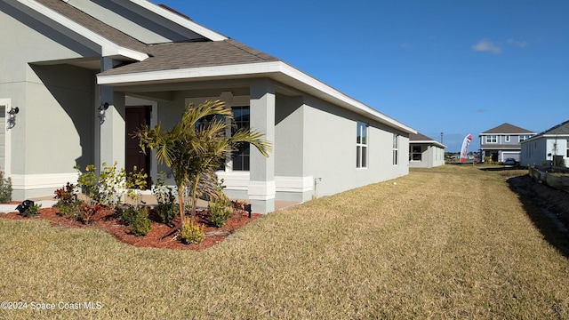 view of side of home with a yard