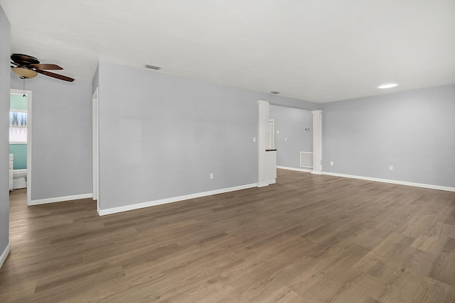 unfurnished room featuring hardwood / wood-style floors, ceiling fan, and ornate columns