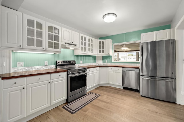 kitchen with stainless steel appliances, sink, light hardwood / wood-style floors, and white cabinets