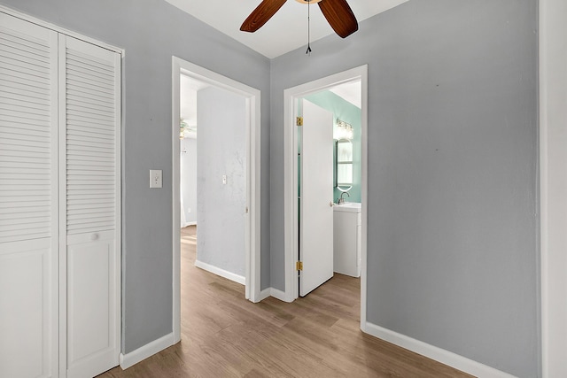 corridor featuring sink and light hardwood / wood-style floors