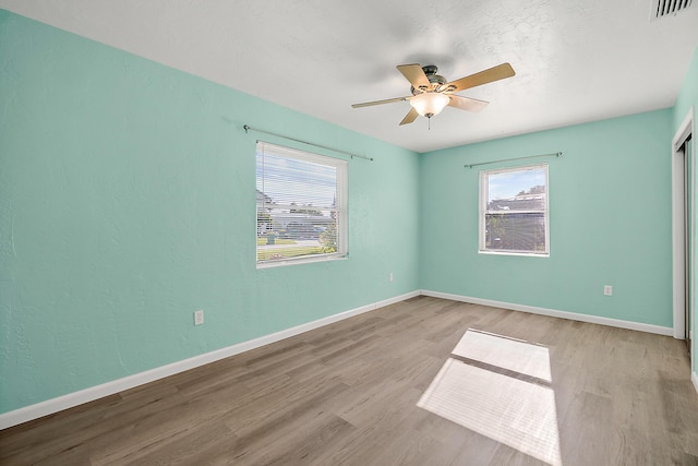 spare room with ceiling fan and light wood-type flooring