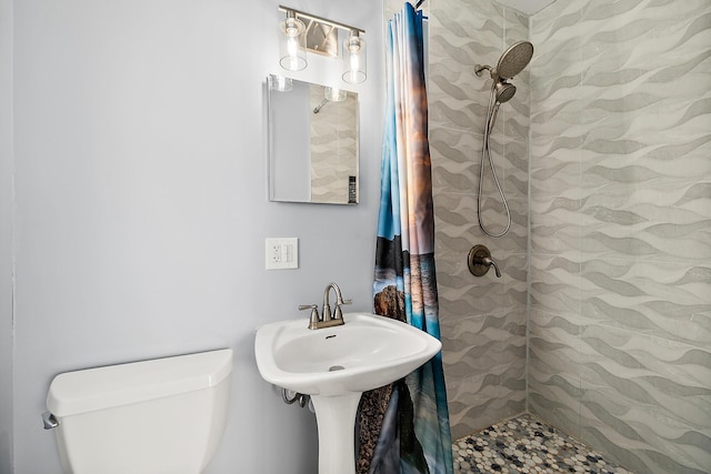 bathroom with a shower with shower curtain and toilet