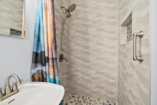 bathroom featuring sink and a tile shower