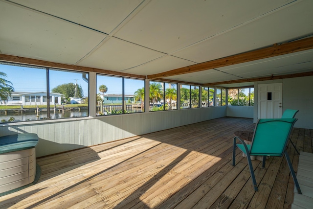 unfurnished sunroom featuring a water view