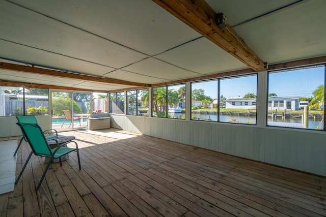 unfurnished sunroom with a water view