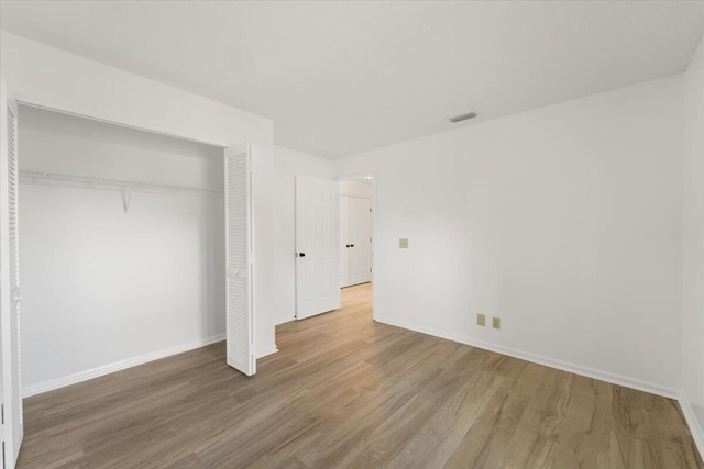 unfurnished bedroom featuring wood-type flooring and a closet