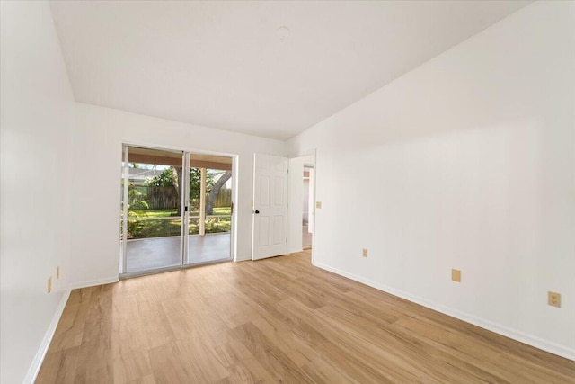 unfurnished room featuring light wood-type flooring and lofted ceiling