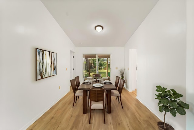 dining area with lofted ceiling and light wood-type flooring