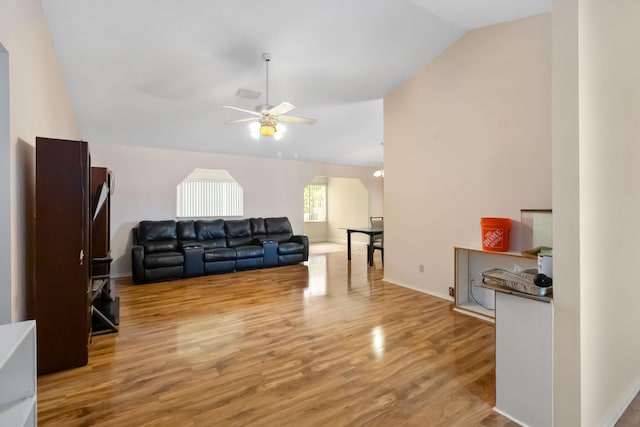 living room featuring ceiling fan, vaulted ceiling, and light wood-type flooring